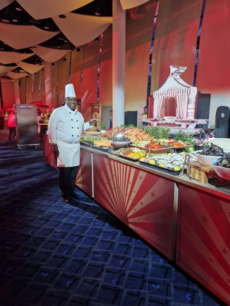 A chef beside a prepared event buffet in the original Asombo gallery